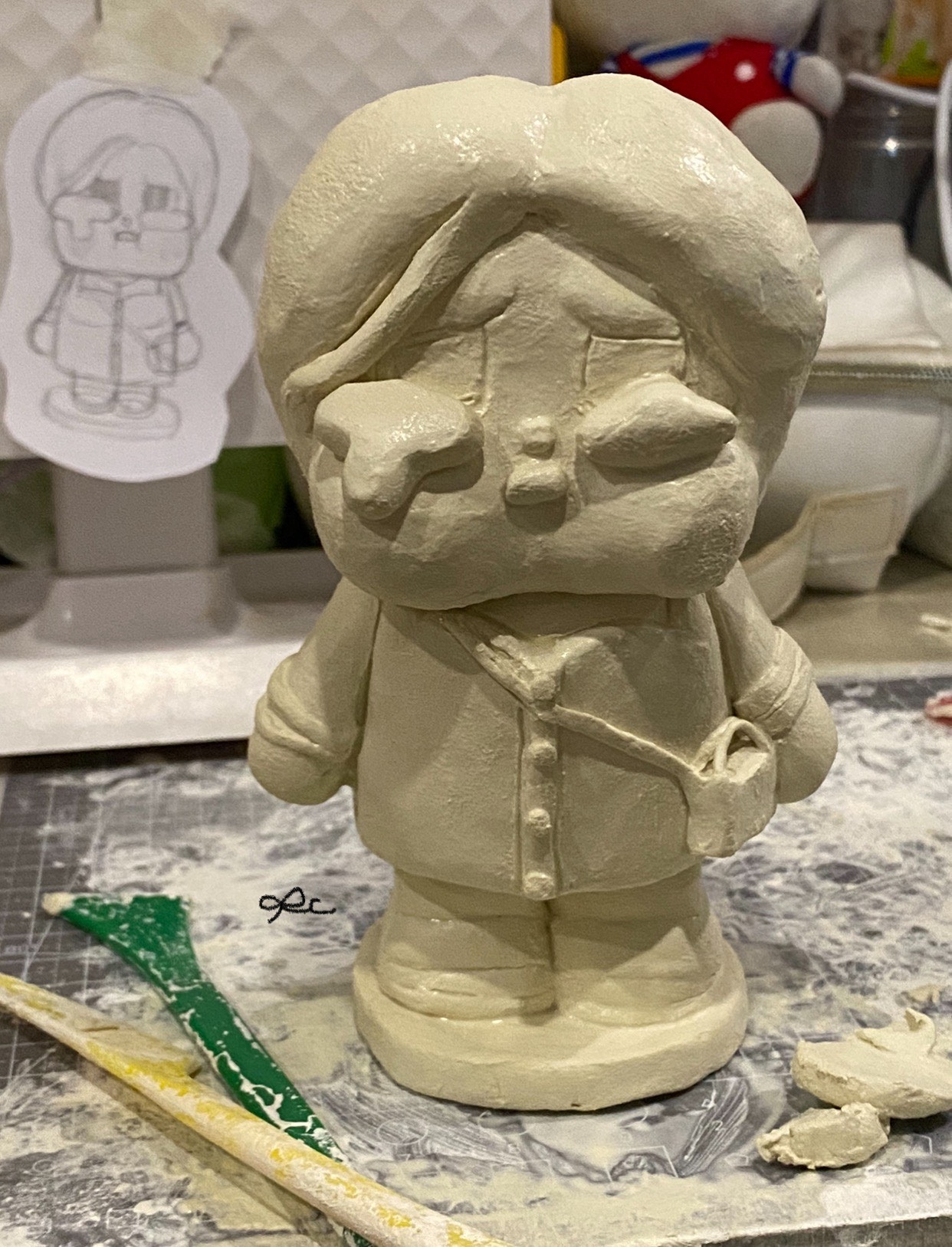 Unpainted clay character figure with a rounded head and short body.