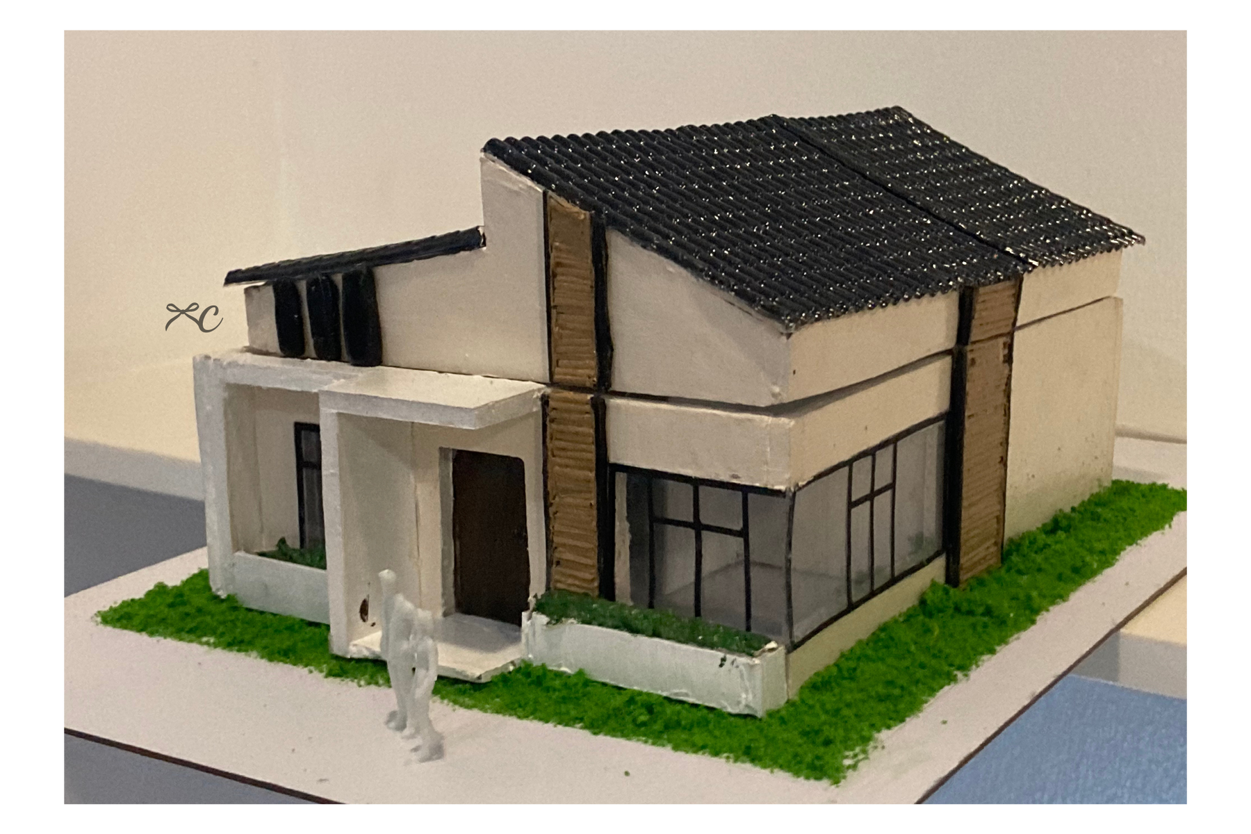 Angled view of a white and timber house scale model with a dark roof.