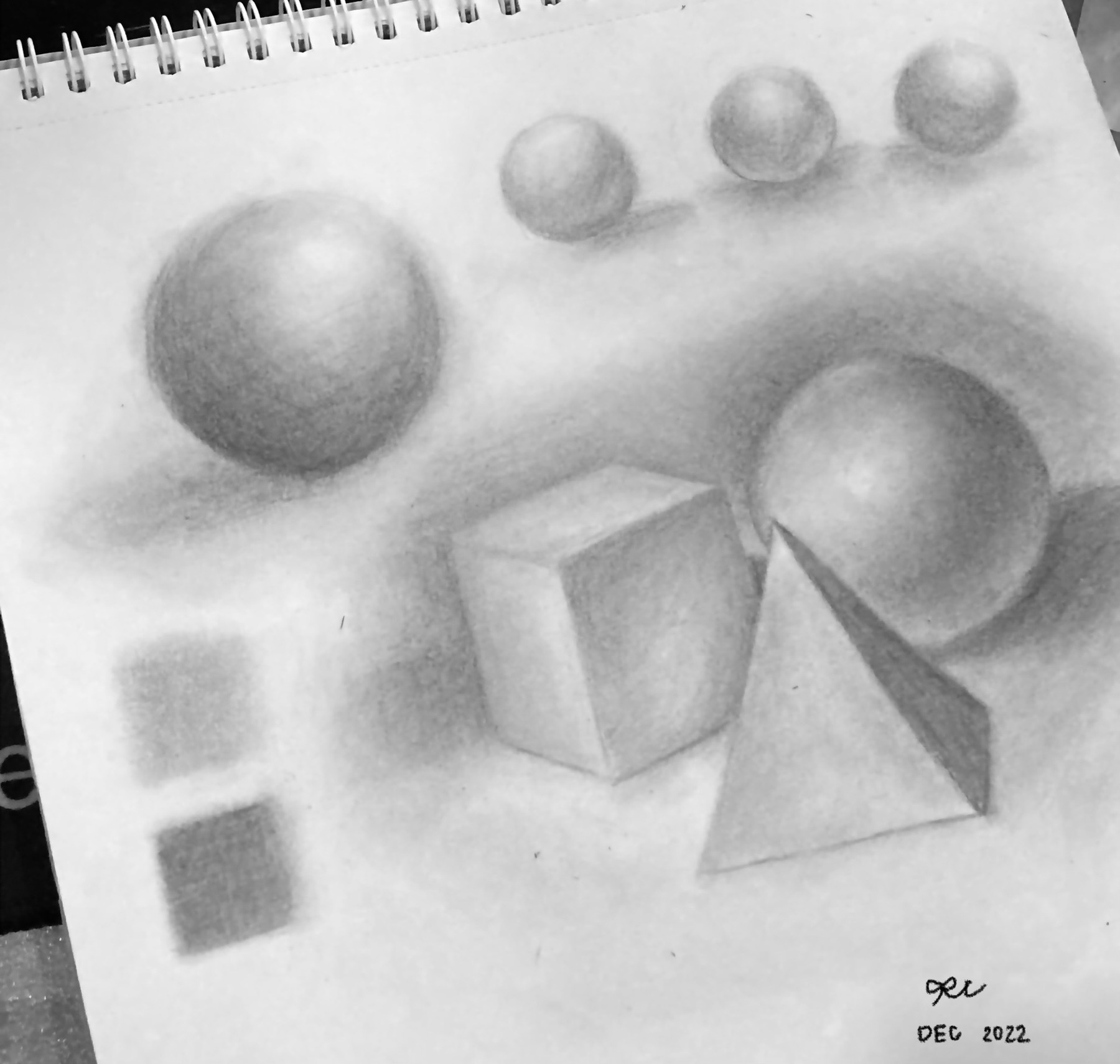 Shaded graphite studies of spheres, a cube, a pyramid, and small squares.